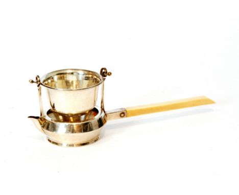 A hallmarked silver tea strainer, the plain bowl with small spout and ivory stick handle below pierced bowl suspended by twin