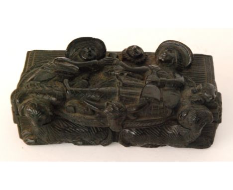 A 19th Century Dutch carved ebonised oak snuff box depicting a medieval scene of two reclining figures sharing a cup of wine 