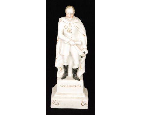 A 19th Century Staffordshire portrait figure of the Duke of Wellington, he stood in uniform and a cloak holding a scroll in o