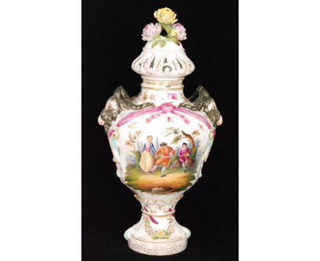 A large early 20th Century pedestal vase and cover decorated with hand painted cartouche panels depicting figures playing mus