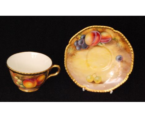 A matched Royal Worcester Fallen Fruits cabinet teacup and saucer, the teacup with hand painted peaches and grapes by J. Cook