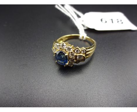 AN 18K GOLD (750) CLUSTER RING SAPPHIRE? SURROUNDED BY DIAMONDS 5.6g