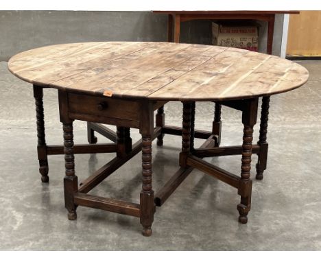 A yew wood dropleaf table on bobbin turned legs and double gateleg supports. The frieze with a drawer. 53' wide.