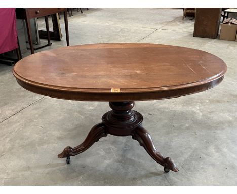 A Victorian mahogany snap-top supper table, the oval top on turned column and tripod support. 52' long