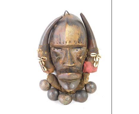 An African Tribal Dan Kran warrior's mask, with fabric border applied with shells and bells, Cote D'Ivoire circa 1940, 30cm h