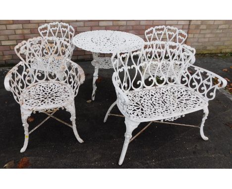 A cream painted cast metal garden table, with pierced decoration, 80cm diameter, matching sofa and three armchairs.  