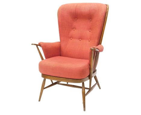 An Ercol stick back armchair, pulsing red fabric on turned legs.  The upholstery in this lot does not comply with the 1988 (F