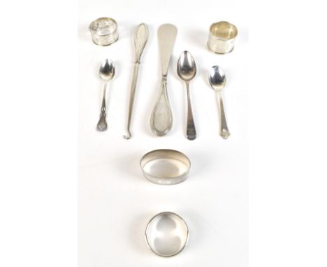 A group of variously hallmarked silver items comprising three teaspoons, four single napkin rings and a silver handled matchi