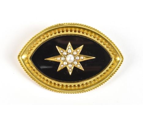 A Victorian yellow metal mourning brooch with central black enamelled panel set with a star of cultured pearls within a doubl