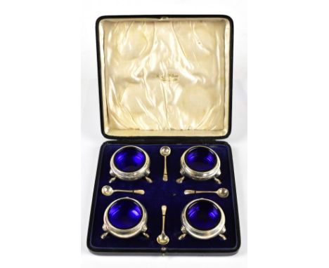 HASELER BROTHERS; a cased set of four George V hallmarked silver open salts with matched silver spoons, each of circular form