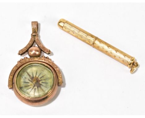 A 9ct yellow gold revolving tooth pick with engine turned decoration, length 7.7cm, and a yellow metal compass fob, approx 17