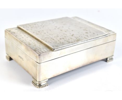 WILLIAM NEALE LTD; an Art Deco George V hallmarked silver cigarette box with engine turned detail on four cast feet with two 