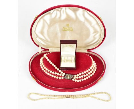A three strand pearl necklace with a white metal clasp marked 14k, a single pearl strand necklace with a 9ct yellow gold clas