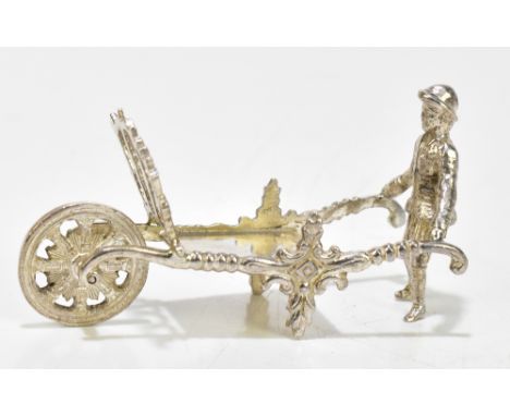 A Dutch silver model of a gentleman pushing a wheelbarrow, London import mark 1974, length 8cm, approx 1.2ozt/39g.Additional 