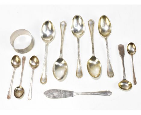 A group of variously hallmarked silver spoons, a butter knife and a single napkin ring with engine turned detail and engraved