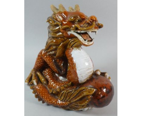 A Chinese Ceramic Study of a Seated Coiled Dragon Holding Pearl, 26cm High 