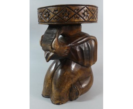 A Carved Wooden Novelty African Stool in the Form of a Seated Elephant with Trunk in Salute, 35.5cm High 