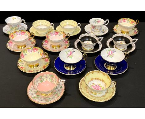A pair of Swansea pattern Staffordshire teacups and saucers, others similar in pairs, printed with colourful flowers with gil