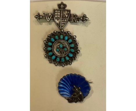 A silver Queen Victoria 'VR' brooch, Birmingham 1896; an enamel pixie brooch, marked Sterling; turquoise and silver brooch (3