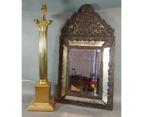 A brass lamp of column form together with a metal mounted wall mirror 