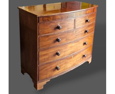 A 19th Century mahogany bow fronted chest with a concealed drawer above two short and three long drawers with knob handles ra