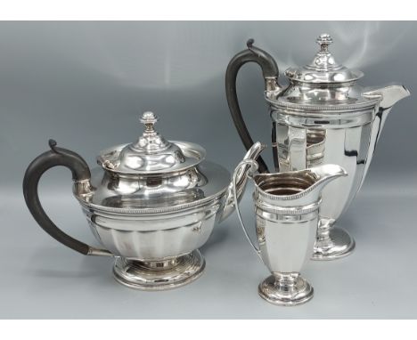 A George V silver three piece tea service comprising teapot, hot water pot and cream jug, Sheffield 1915, makers Finnigans Lt