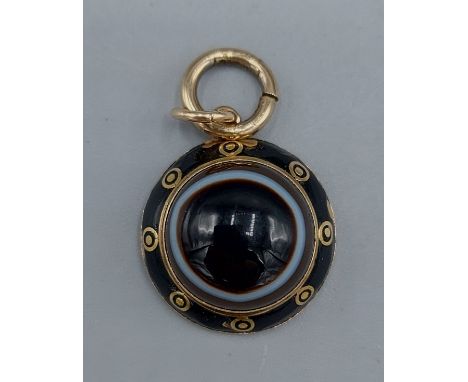 A 19th Century mourning pendant set Tigers Eye and black enamel 