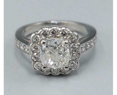 A Platinum and Diamond cluster ring set with a large central diamond surrounded by diamonds and with diamond shoulders, centr