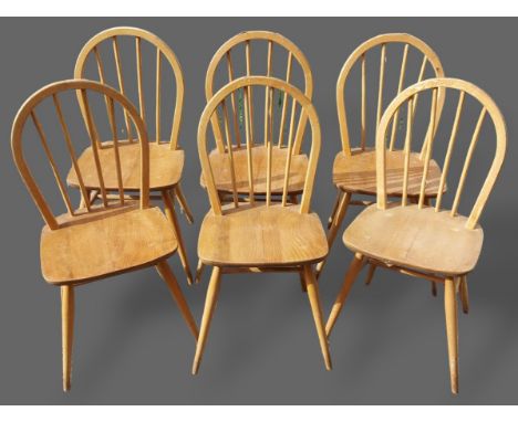 A set of six Ercol blonde Ash stick back dining chairs, each with a panel seat raised upon turned legs with stretchers