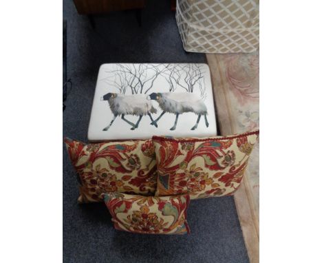 A contemporary footstool upholstered in sheep patterned print together with three tapestry style cushions 