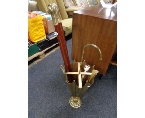 A brass umbrella stick stand containing two brass headed walking sticks, two shoe horns 