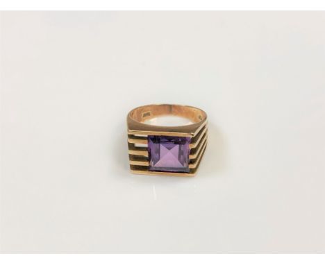 A 14ct gold 70's style ring set with a square cut purple stone, size K/L.