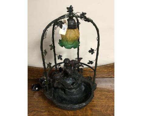 A cherub water feature fitted with a light and two tone glass shade 