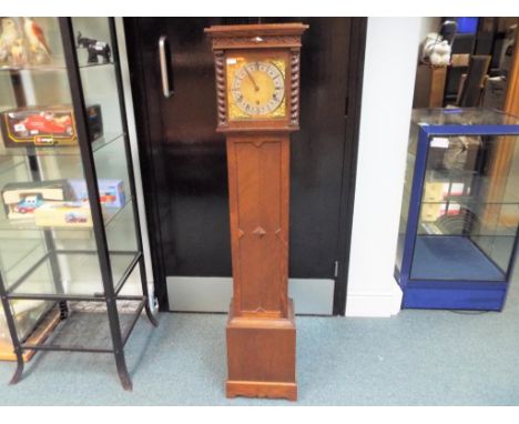 An early 20th century oak cased granddaughter clock, having Roman numerals on a silvered chapter ring on a matted brass centr