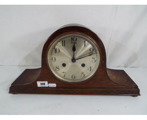 A good quality oak cased mantel clock with carved decoration, Arabic numerals to the dial and pendulum.