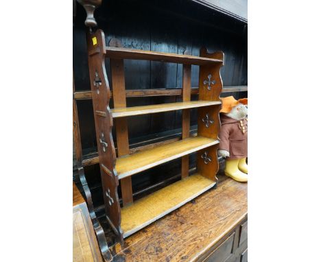 An antique oak hanging open wall shelf, with pierced quatrefoil ends, 55.5cm wide.&nbsp;&nbsp; 