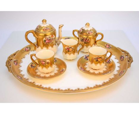 A Coalport gilt and floral cabaret service, circa 1885, comprising coffee pot and cover, cream jug, twin-handled sucrier and 