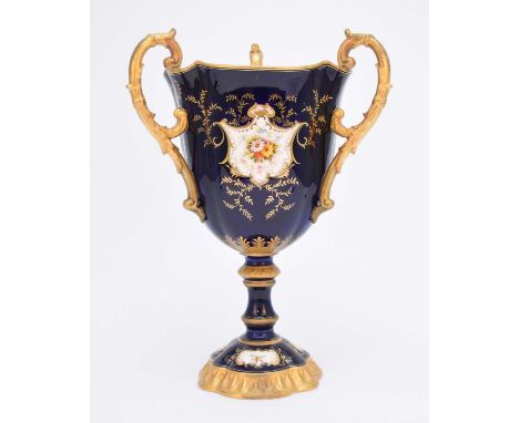 A large Coalport trophy cup, circa 1891-1919of chalice form with three handles on a pedestal foot, the bowl painted with a la