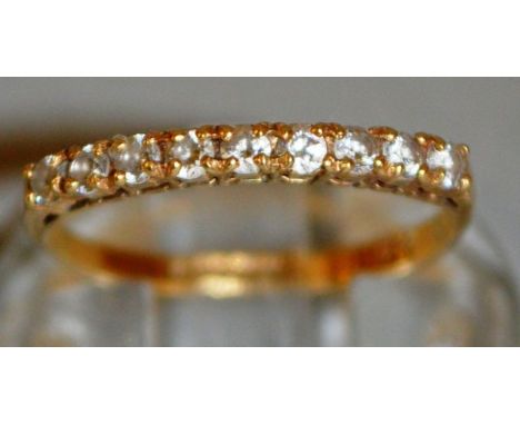 A NINE STONE HALF ETERNITY RING set in 9ct gold.