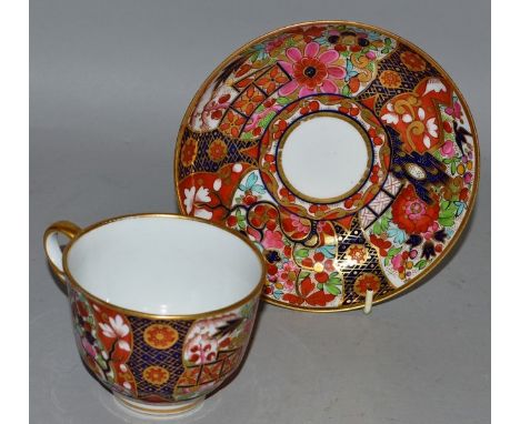 AN EARLY 19TH CENTURY WORCESTER BARR FLIGHT AND BARR TEACUP AND SAUCER, painted in a bright imari fence pattern, impressed BF