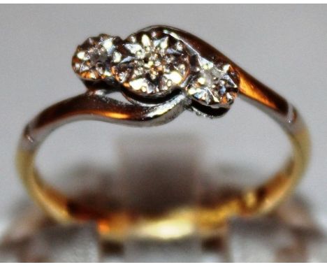 A THREE STONE DIAMOND CROSSOVER RING set in 18ct yellow gold.