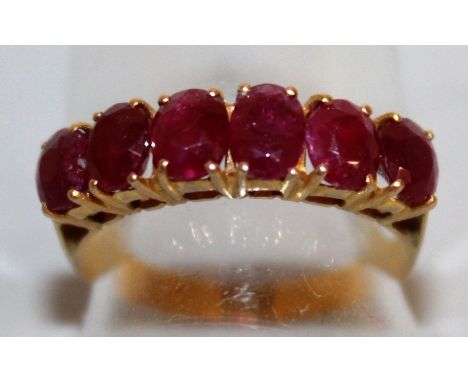 A VERY GOOD SIX STONE RUBY RING set in yellow gold.