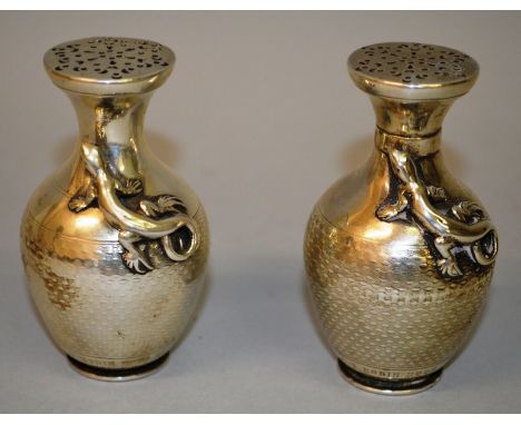 A PAIR OF VICTORIAN ELKINGTON & CO ENGINE TURNED SILVER PEPPER POTS with lizards in relief Engraved HON’BLE AUBREY C. T. ROBI