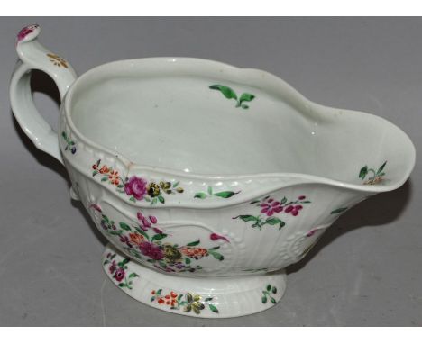AN 18TH CENTURY WORCESTER SAUCEBOAT of strap fluted form, unusually painted with polychrome flowers, most examples of this sh