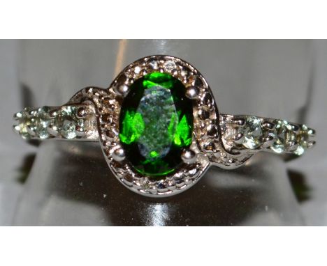 A 9CT GOLD, EMERALD AND DIAMOND OVAL CLUSTER RING.