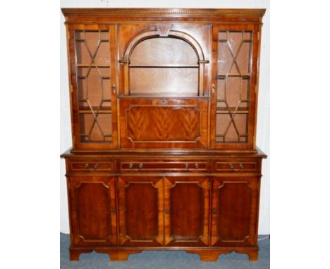 A GEORGIAN STYLE YEW WOOD BOOKCASE, the top with open shelf, fall flap with a pair of astragal doors on a base with three sma