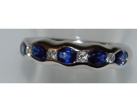 A SAPPHIRE AND DIAMOND HALF HOOP RING set in 18ct white gold.