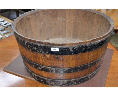 An oak planter made from a coopered barrel.