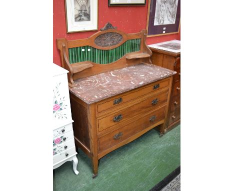An oak Art Nouveau washstand, tile back, rouge marble top, three graduated drawers to base, tapering square legs, ceramic cas