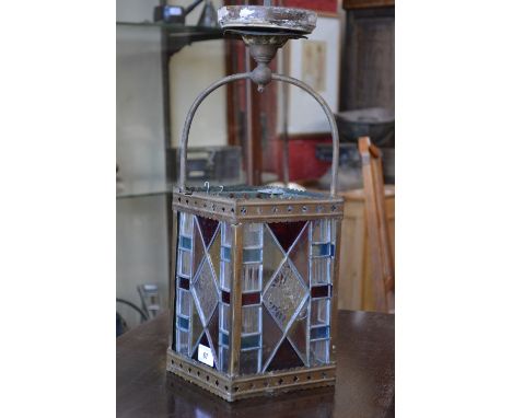 A gas lamp with stained glass shade.